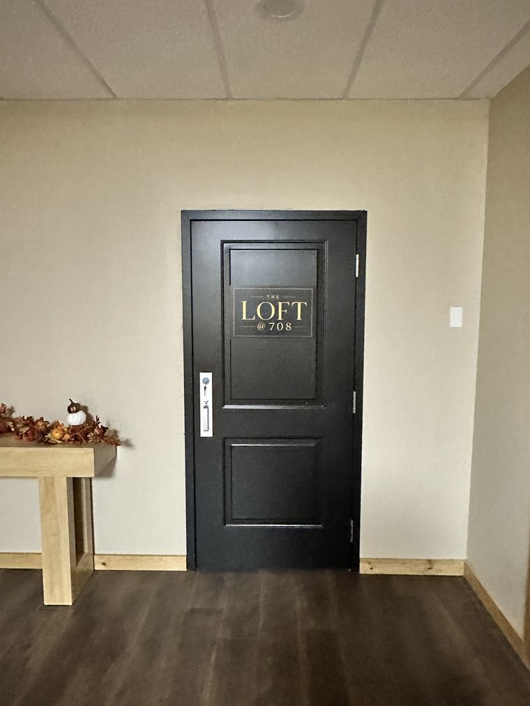 The black door to The Loft, with its name in gold letters